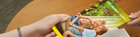 une main transmet un exemplaire imprimé du guide du membre VRS à une autre main située de l'autre côté d'une table