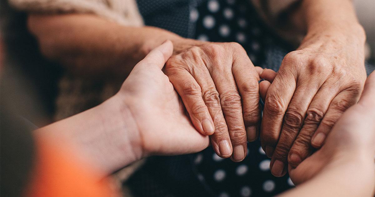 Decorative. A pair of older hands holding onto a pair pf younger hands.