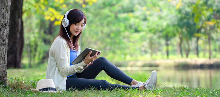 A person sitting on grass reading a book