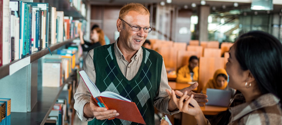 A person in a vest holding a book