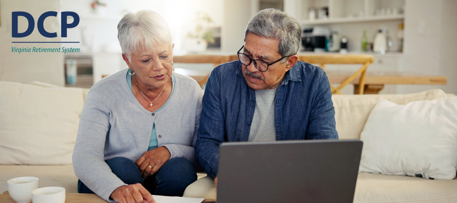 Two adults sitting together at home reviewing retirement information on a laptop computer.
