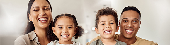 A happy family of four smiling and laughing