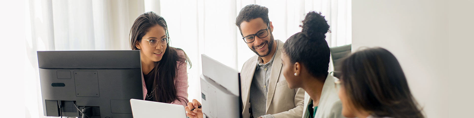 Nagtipon-tipon ang mga empleyado sa isang mesa sa harap ng isang computer