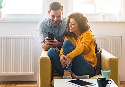 ایک مرد اور عورت ایک ساتھ سیل فون کی اسکرین کو دیکھ رہے ہیں۔